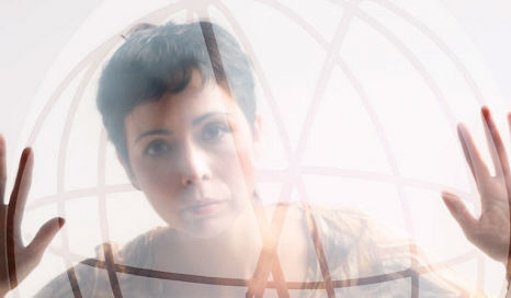 women looking intently into glass sphere